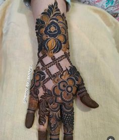 a woman's hand with henna tattoos on it