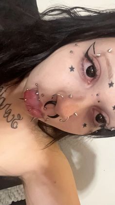 a woman with black hair and tattoos on her face