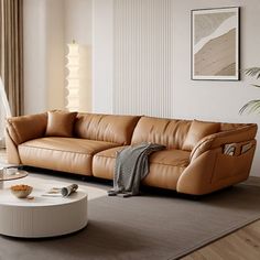 a living room with a couch, coffee table and potted plant in the corner