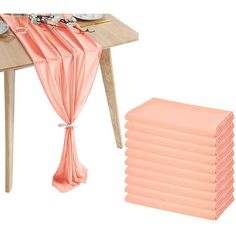 a table topped with plates and napkins next to a stack of pink napkins