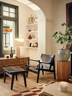 a living room filled with furniture and a potted plant on top of a table