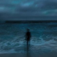 a person standing in the ocean at night