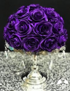 a bouquet of purple roses sitting on top of a table