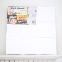 the edge of a white shelf with several pieces of paper attached to it and a magazine on top