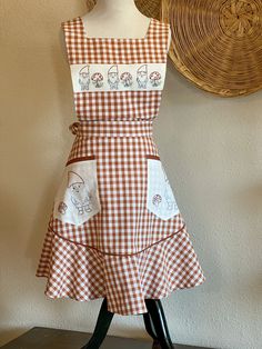 an apron on a mannequin next to a wall with a basket in the background