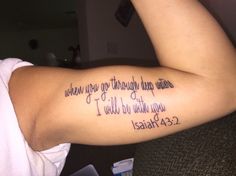 a woman's arm with a bible verse tattoo on it