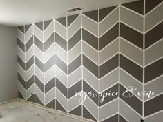 a room that has been painted with gray and white chevrons on the wall