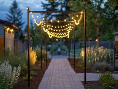 a walkway with lights strung over it and some trees in the backgrouf