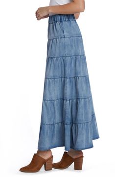 The season-staple denim maxi skirt is updated with a flouncy tiered ruffles and an easy elastic waistband. Elastic waist Unlined 62% lyocell, 20% cotton, 12% polyester, 5% rayon, 1% spandex Machine wash, tumble dry Imported Spring Tiered Denim Skirt, Medium Wash Ruffled Skirt For Spring, Spring Medium Wash Tiered Skirt, Summer Denim Tiered Maxi Skirt, Denim Tiered Maxi Skirt For Summer, Ruffled Medium Wash Skirt For Spring, Blue High Rise Maxi Skirt For Spring, Flowy Denim Tiered Skirt, Denim Blue Tiered Cotton Skirt