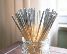 a glass jar filled with toothpicks on top of a wooden table