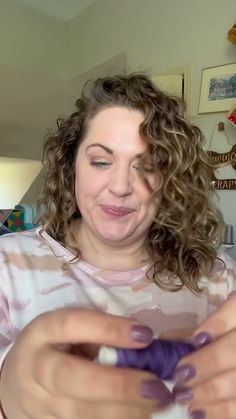 a woman with curly hair holding something in her hands