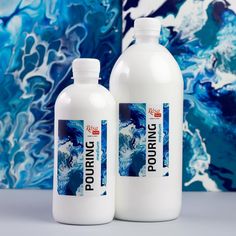 two bottles of liquid sitting next to each other on a white surface with blue swirls in the background