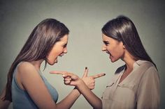 two young women making faces and pointing fingers at each other