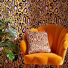 an orange chair sitting in front of a leopard print wall