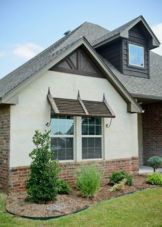 the front of a house with landscaping and shrubs