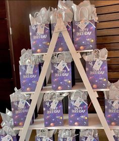 a wooden stand with bags on it that have the words happy birthday written on them