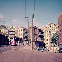 an old city street with cars parked on the side