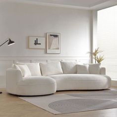 a large white couch sitting in a living room on top of a hard wood floor