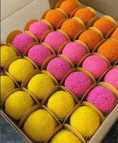 there are many different colored balls in the box and one is pink, yellow, and orange