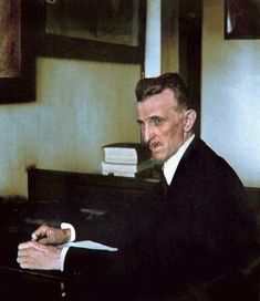 a man sitting at a desk writing on a piece of paper with a pen in his hand