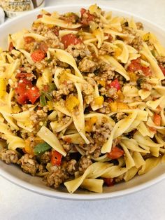 a white bowl filled with pasta and meat