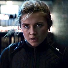 a close up of a person wearing a jacket and looking at the camera with an intense look on her face