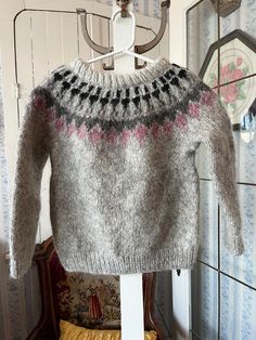 This is a gorgeous sweater, knit by hand from thick chunky wool in grey and decorated on the front and back yokes with a pattern in black, dark grey and raspberry pink. The measurements, taken with the sweater lying flat, are: shoulder to shoulder, 14 inches; armpit to armpit, 15 inches; sleeves, 15 inches; length, 16 inches; bottom edge, 11 inches (with stretchy ribbing). In very good condition. Cozy Gray Sweater With Fair Isle Pattern, Sweater Handmade, Kids Jumpers, Wool Pullover, Raspberry Pink, Chunky Wool, Pink Trim, Kids Sweater, Black And Pink