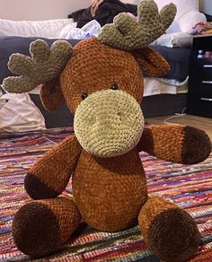 a stuffed moose sitting on top of a rug