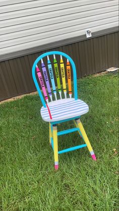 a colorful wooden chair sitting in the grass