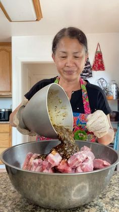 a woman pouring something into a metal bowl