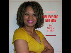 a woman with her arms crossed standing in front of a sign that says believe god not man