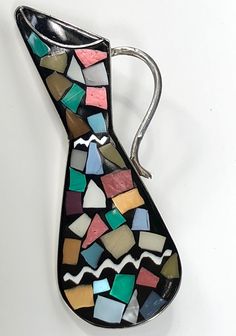 "Mid Century Sterling Mosaic brooch Israel This beautiful Mid Century brooch is made of sterling silver and Israeli mosaic with a black bath round and chips of metallic and iridescent colors set into the the front surface of the brooch. The shape of this piece is a elegant tall vessel, a jug or a pitcher. The handle of the pitcher is graceful and sterling silver. The back is marked Made in Israel 925 (for sterling silver). this piece closes with a rolling clasp but also has a silver bale so that Black Bath, Holiday Christmas Gifts, Vintage Brooch, Mid Century Style, Vintage Porcelain, Vintage Gifts, Color Set, Vintage Brooches, Gifts Photos