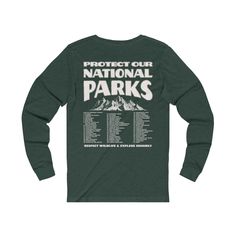 "This classic Unisex long sleeve tee features \"Protect Our National Parks / Respect Wildlife & Explore Sensibly\" with a vintage mountain illustration and a complete list of all 63 National Parks in the U.S. on the back and a badge on the front pocket side. This shirt is perfect for raising awareness about the \"Leave No Trace\" principles when exploring the outdoors as well as being a unique U.S. National Park bucket list! Make sure to check out the other garment options below :) » O P T I O N Park Ranger Aesthetic, Ranger Aesthetic, National Park Bucket List, Respect Wildlife, Camping Clothes, Mountain Graphic Tee, Retro Mountain, Mountain Graphic, Indie Clothing