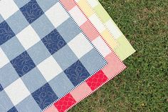 a patchwork quilt laying on the grass