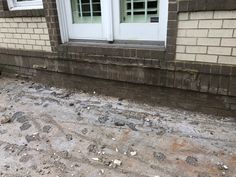 an image of the outside of a house that has been gutted with dirt and rocks