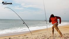 the man is fishing on the beach with his rod