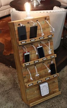 a phone charging station made out of pallet wood with multiple cell phones attached to it