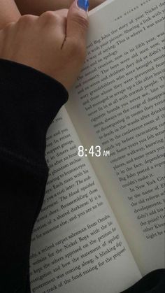 a person is holding a pen in their hand and writing on an open book with the words 8 13 am