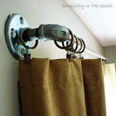 a curtain is hanging on the side of a window with an old fashioned shower rod