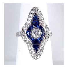 a blue and white diamond ring sitting on top of a table