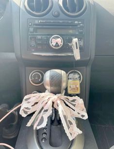 a car dashboard with an air vent and radio in the center, decorated with ribbon