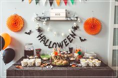 a table with halloween decorations and desserts on it