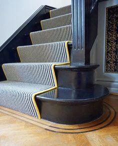 the stairs are painted black and white with yellow trimmings, along with a rug on the floor