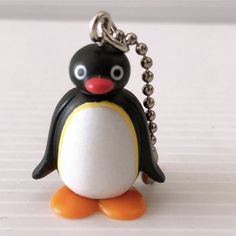 a penguin keychain with a black and white penguin on it's back