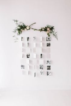 a white wall with flowers and photos hanging on it