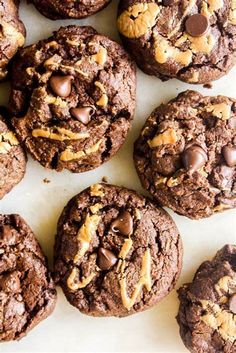 chocolate chip cookies with peanut butter and chocolate chips in the middle on a white surface