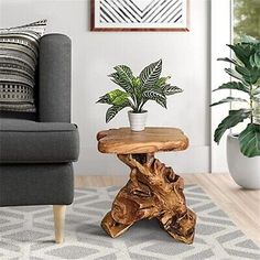 a wooden table with a potted plant on it in front of a gray couch