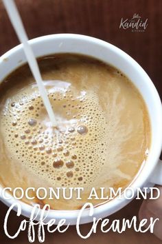 a cup of coffee with milk being poured into it and the words coconut almond coffee creamer