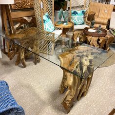 a glass table with wooden logs on it in a room filled with furniture and decor