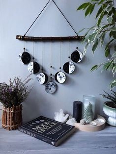 a book is sitting on a table next to a plant and some plates hanging from a wall